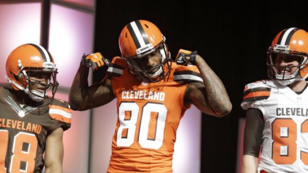 Cleveland Browns' Dwayne Bowe (80) flexes for the crowd as Taylor Gabriel (18) and Brian Hartline (83) watch as they show off the NFL football team's new uniforms to fans Tuesday, April 14, 2015, in Cleveland. After two years of planning and months of speculation and secrecy, the Browns unveiled uniforms they hope will be a big hit. (AP Photo/Tony Dejak)