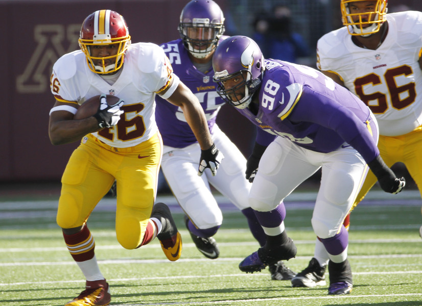 Washington Redskins running back Alfred Morris, left, runs from Minnesota Vikings defensive tackle Linval Joseph (98) during the first half of an NFL football game, Sunday, Nov. 2, 2014, in Minneapolis. (AP Photo/Ann Heisenfelt)