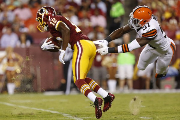 Aug 18, 2014; Landover, MD, USA; Washington Redskins wide receiver Andre Roberts (12) returns a punt past Cleveland Browns linebacker Barkevious Mingo (51) in the first quarter at FedEx Field. Mandatory Credit: Geoff Burke-USA TODAY Sports