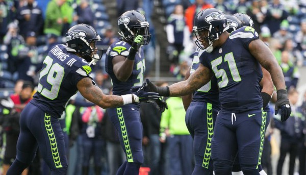 Seahawks linebacker Bruce Irvin, right, Seahawks safety Earl Thomas and Seahawks safety Kam Chancellor warm up before the Seattle Seahawks take on the Carolina Panthers at CenturyLink Field in Seattle Sunday, October 18, 2015.