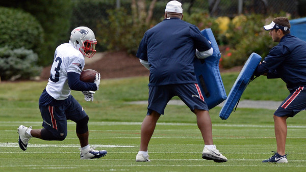 (Foxboro, MA, 09/14/15) New England Patriots running back Dion Lewis, left, carries the ball into a pair of coaches while participating in a drill during practice at Gillette Stadium in Foxboro on Monday, September 14, 2015. Staff photo by Christopher Evans