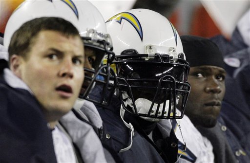 FILE - In this Jan. 20, 2008, file photo, San Diego Chargers quarterback Philip Rivers, left, running back LaDainian Tomlinson, center, and fullback Andrew Pinnock, right, sit on the bench during the third quarter of the AFC Championship football game against the New England Patriots in Foxborough, Mass. Tomlinson, trying to play with a sprained knee, lasted just a few plays before the pain sent him to the sideline while the Chargers lost out on a Super Bowl appearance. Tomlinson sees his next playoff appearance in Foxbourgh as a chance "to redeem myself". (AP Photo/Stephan Savoia, File)