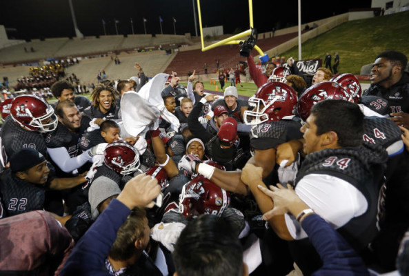 The New Mexico State team celebrate after defensive back Terrill Hanks intercepted a pass from Idaho quarterback Matt Linehan to win 55-48 in overtime their NCAA college football game in Las Cruces, N.M., Saturday, Oct. 31, 2015. (AP Photo/Andres Leighton)