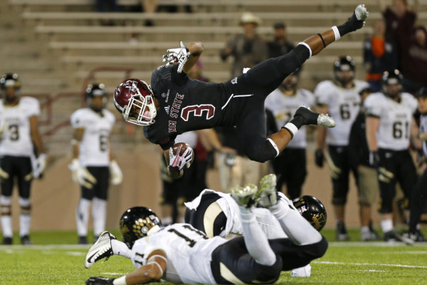 New Mexico State running back Larry Rose III (3) goes airborne after being tripped by Idaho cornerback Kendrick Trotter and safety Russell Siavii (11) during the second half of an NCAA college football game in Las Cruces, N.M., Saturday, Oct. 31, 2015. New Mexico State won 55-48. (AP Photo/Andres Leighton)