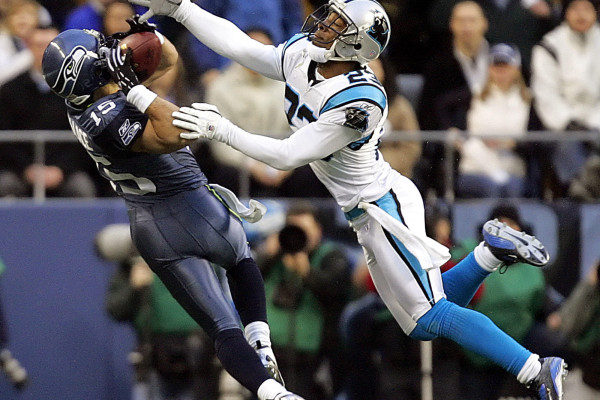 ** FILE ** Seattle Seahawks' Seneca Wallace, left, makes an over-the-shoulder reception as Carolina Panthers' Ken Lucas defends in the NFC championship football game in this Jan. 22, 2006 file photo in Seattle. The catch came during the first game of Wallace's career in which he played wide receiver, but five months later, Wallace is looking for more action as he sits as back-up quarterback and waits for the Seahawks to sign a veteran backup passer to free Wallace to play receiver. (AP Photo/Elaine Thompson, File)