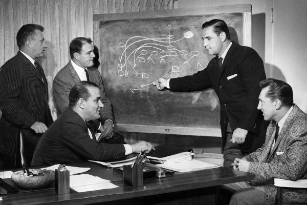 March, 1960: Los Angeles Chargers coaching staff moved into new offices at 1017 La Brea. Here assistant Jack Faulkner diagrams play for Joe Madro, left, Chuck Noll; head coach Sid Gillman (seated) and Al Davis. In 1959, Madra, Faulkner and Gillman were with the Los Angeles Rams; Noll with Cleveland Browns and Davis with USC. This photo was published in the March 15, 1960 Los Angeles Times.