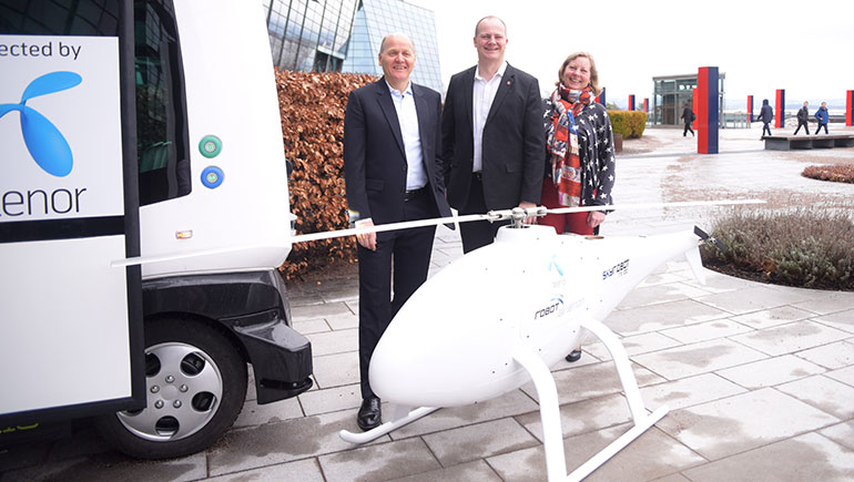Sigve Brekke, Ketil Solvik-Olsen og Berit Svendsen står sammen med en selvkjørende buss og en tilkoblet drone – begge deler en viktig del av 5G-fremtiden.