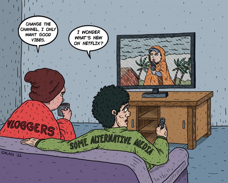 2 people, one has vloggers written on the back, and one has some alternative media, watching a news report of a journalist covering live in the middle of a typhoon.