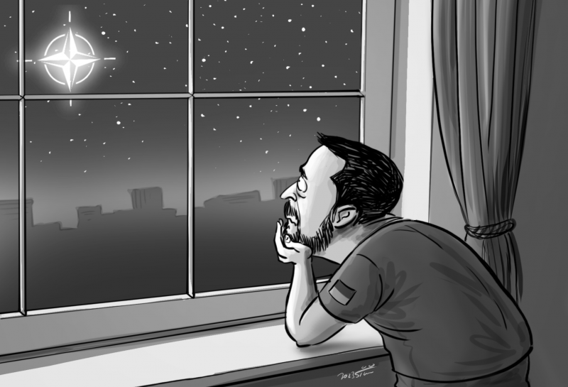 Volodymyr Zelensky leaning on a window looking at a star in shape of the Nato symbol.
