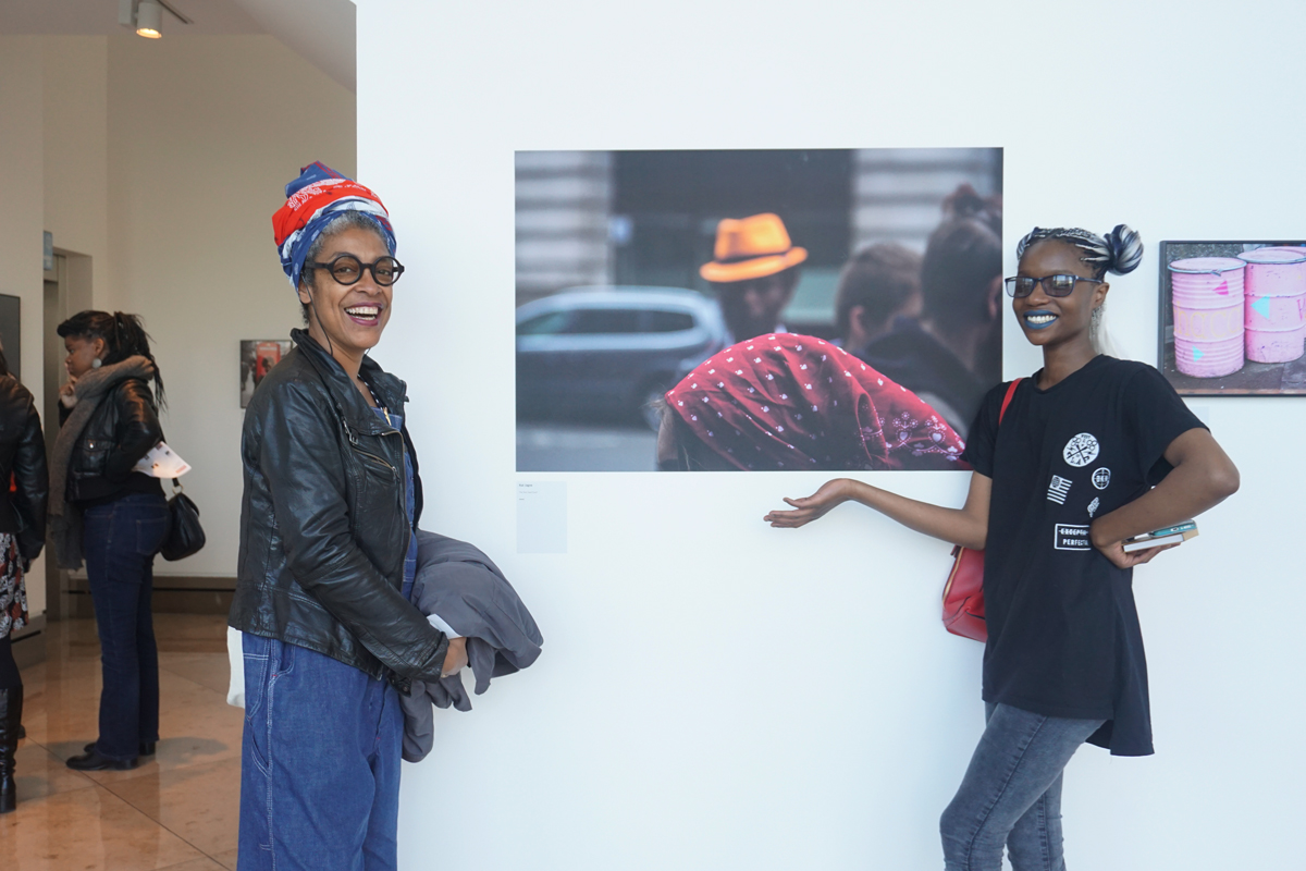 Kat Jagne (right) with one her tutors and her photograph titled 'Red head scarf' at the Made by Us exhibition