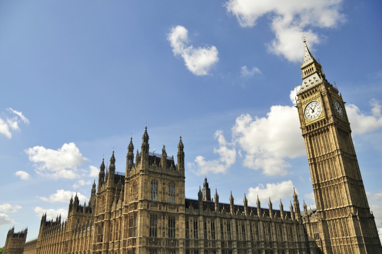 Big blue summer skies with fluffy clouds over the iconic cityscape around the gothic stone architecture of St. Stephens' Tower and the Palace of Westminster, home to the Houses of Parliament and the House of Lords, the government of the UK