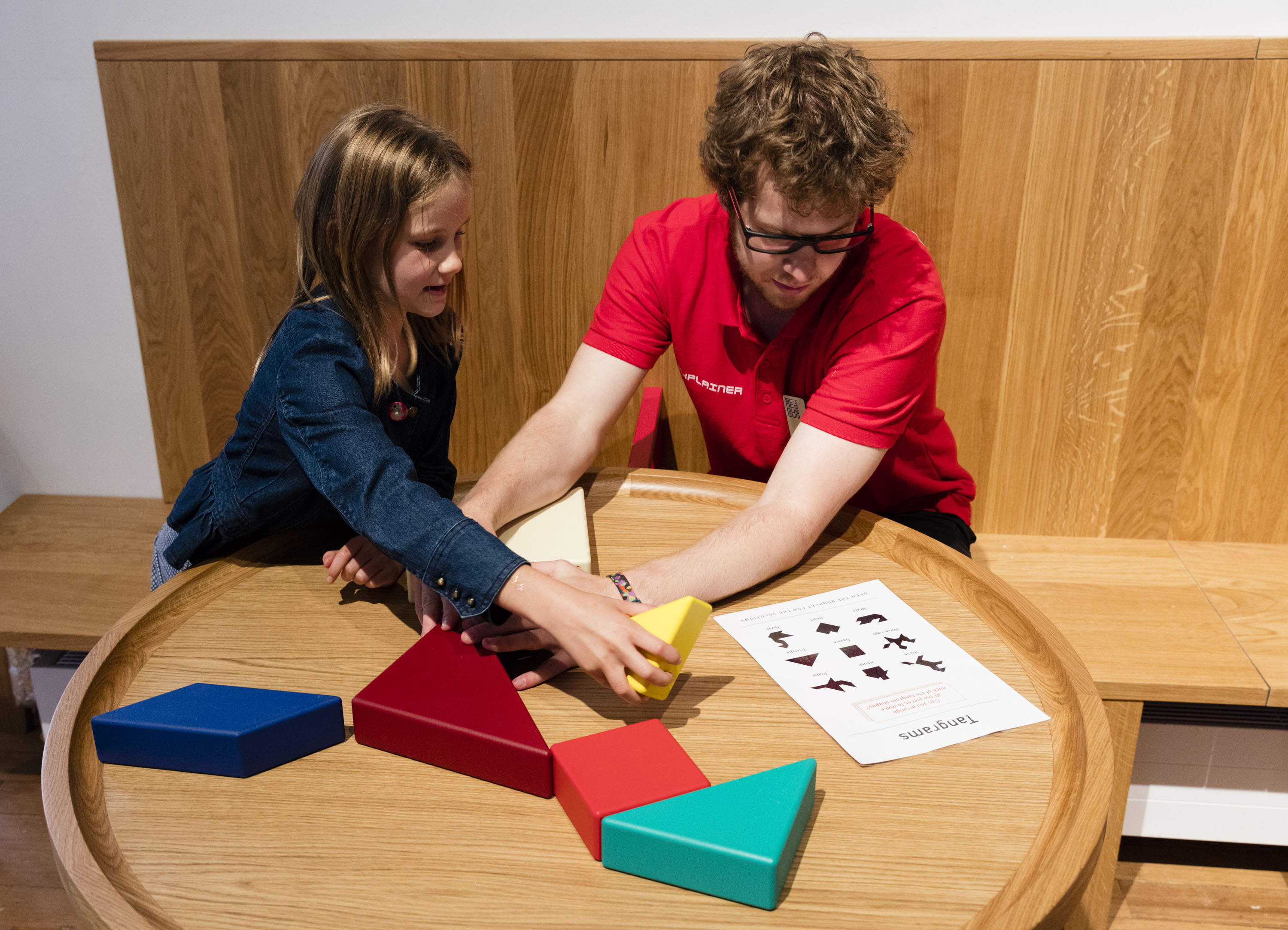 puzzels-an-explainer-and-visitor-solve-a-puzzel-in-wonderlab-%e2%88%8f-plastiques-photography