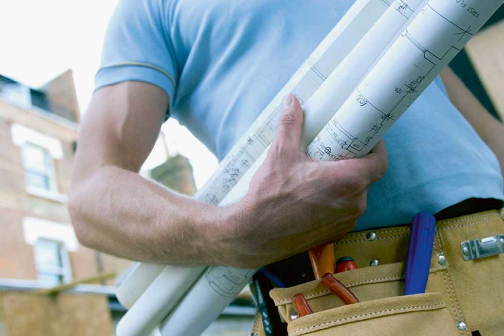 Building project blue prints under mans arm