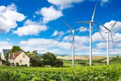 homes with renewable technology and solar panels built next to wind turbines