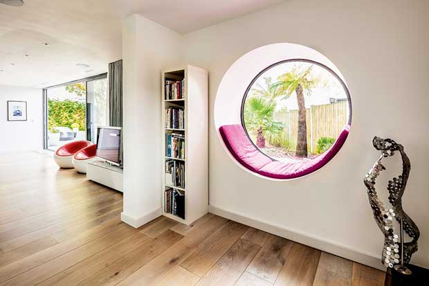 Circular window in a Bauhaus style home with white walls