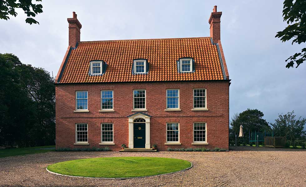 Neil Dowlman Architecture – This Georgian-style brick façade hides a 19th-century cottage behind its walls