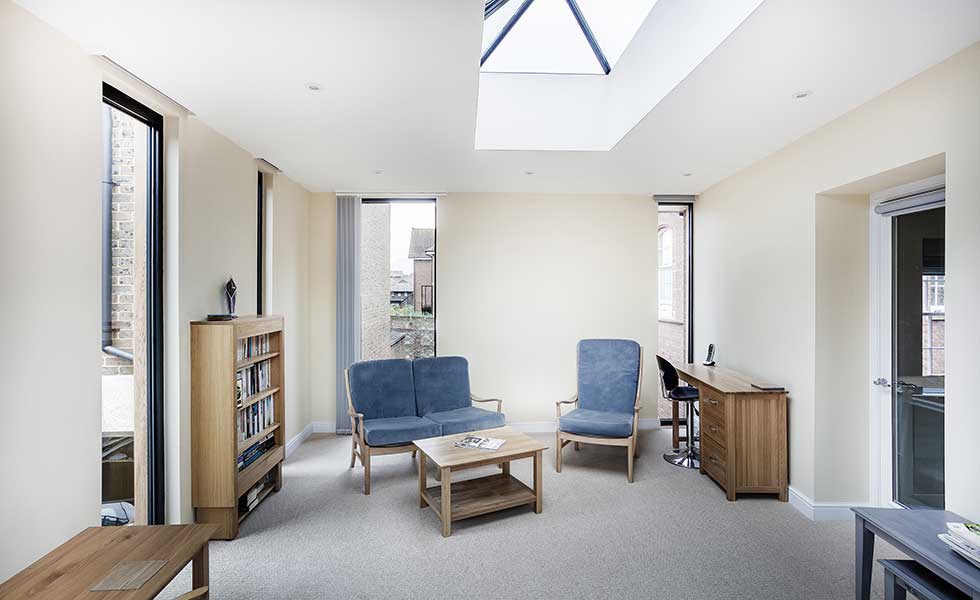 white living space with large skylight and blue furniture
