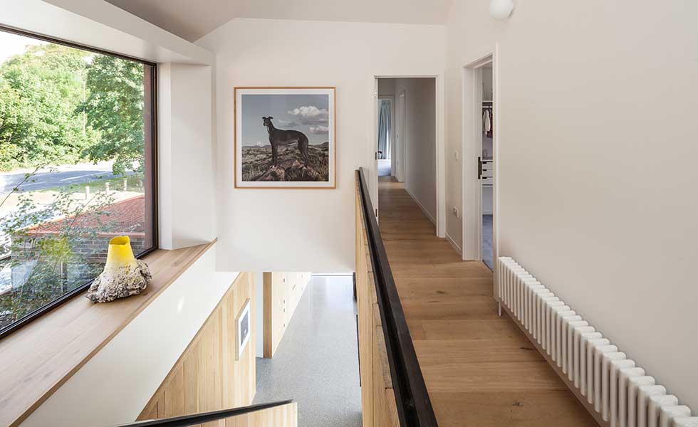 white hallway with wooden flooring and artwork of dog