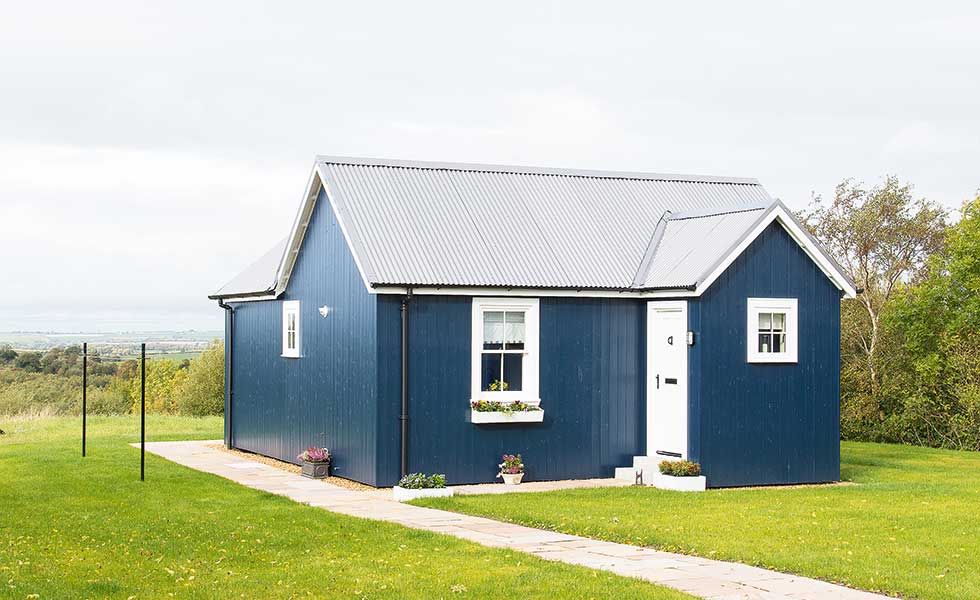blue panelled self build with corrugated roof in scotland