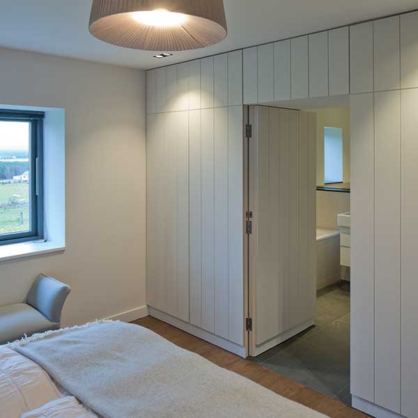 bedroom with cladding walls to bathroom
