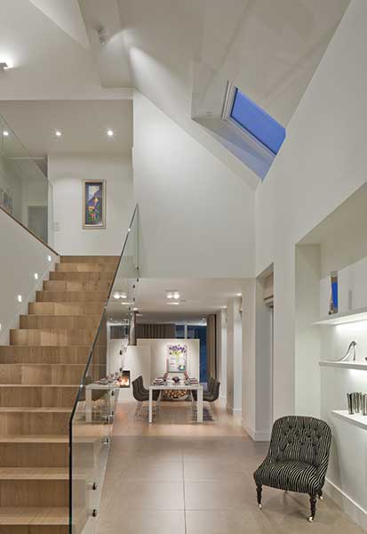 Accent lighting has been introduced in the shelving of this hallway