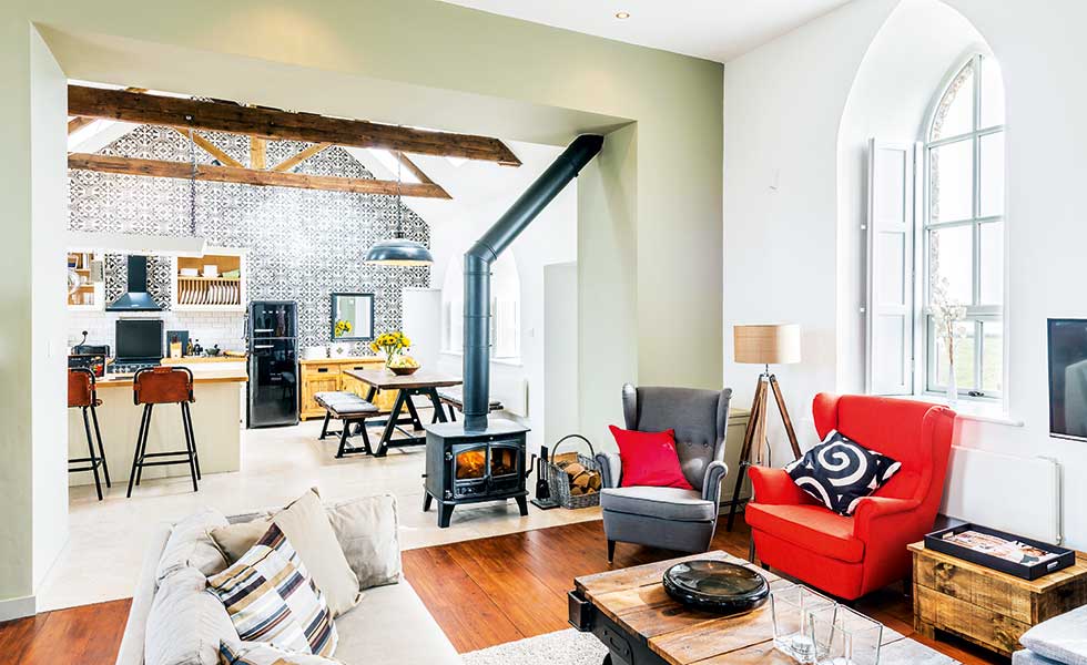 A cosy living room with central woodbruning stove in a chapel conversion in the Pennines