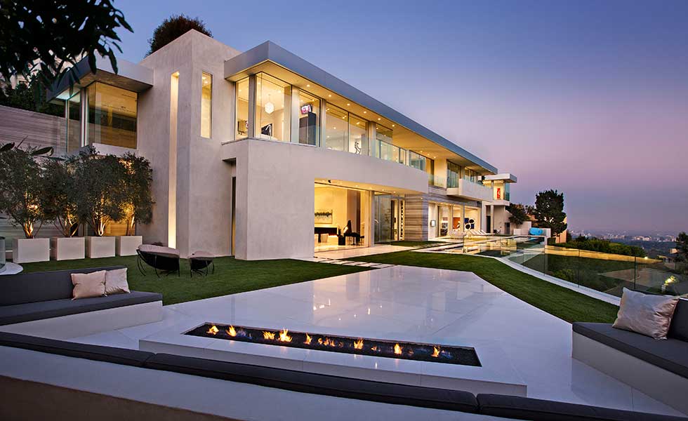 A fantastic Los Angeles home designed by McClean Design lit up at night over the city
