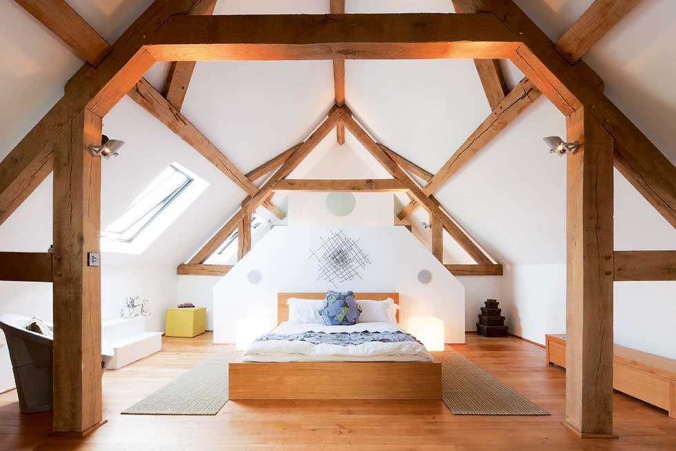 oak frame exposed beams in the bedroom of a barn conversion