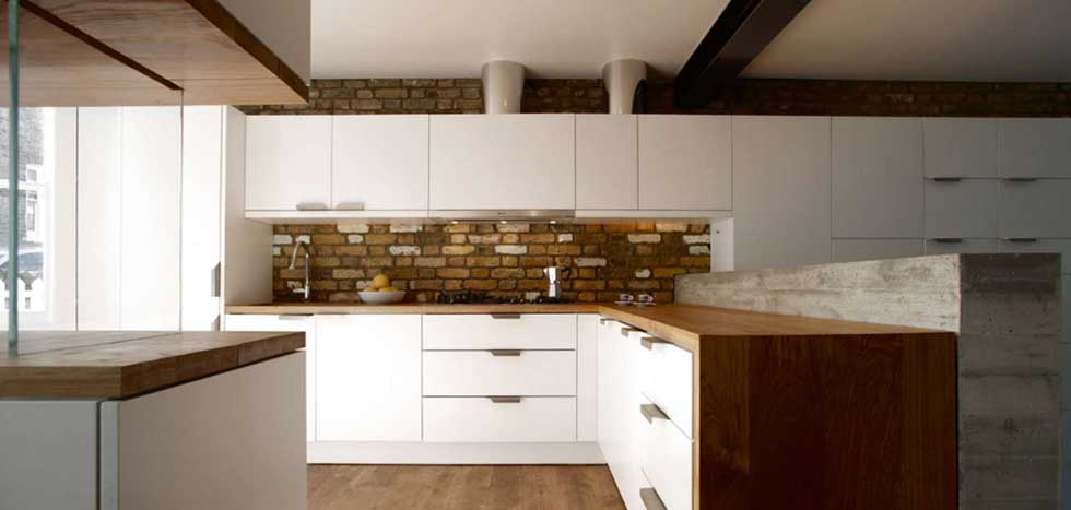 kitchen with exposed brick and white cabinets