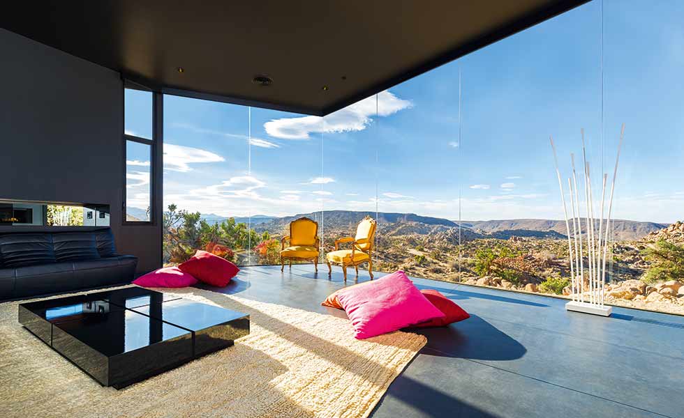 Full-height corner glazing in this American home offers impact upon entry and a great view from the living space