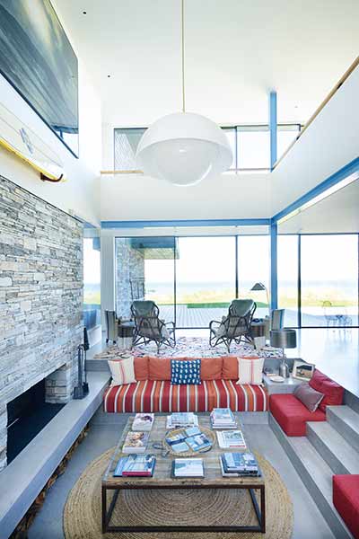 Sunken seating in front of a feature fireplace in a home on the Cornish coast