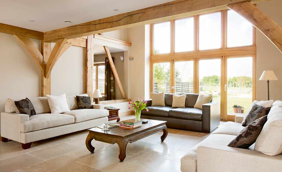Infill glazed panels in this oak frame home helps bring plenty of natural light into the living space which boasts varied ceiling heights