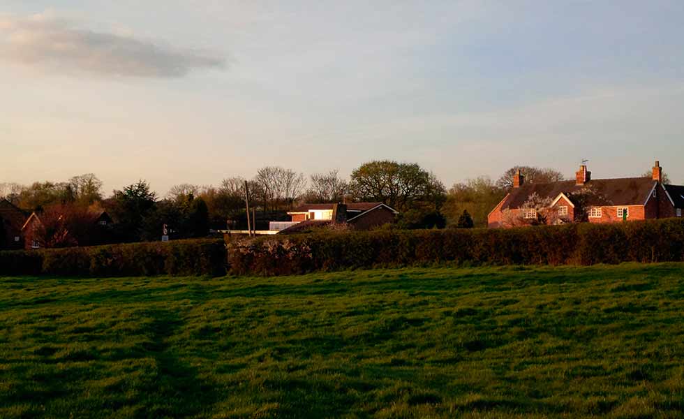Jason and Sarah Orme's 1960s home viewed from across the field at dusk