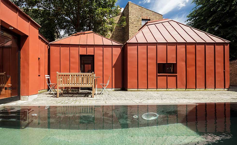 orange metal pavilion style home with courtyard and pool