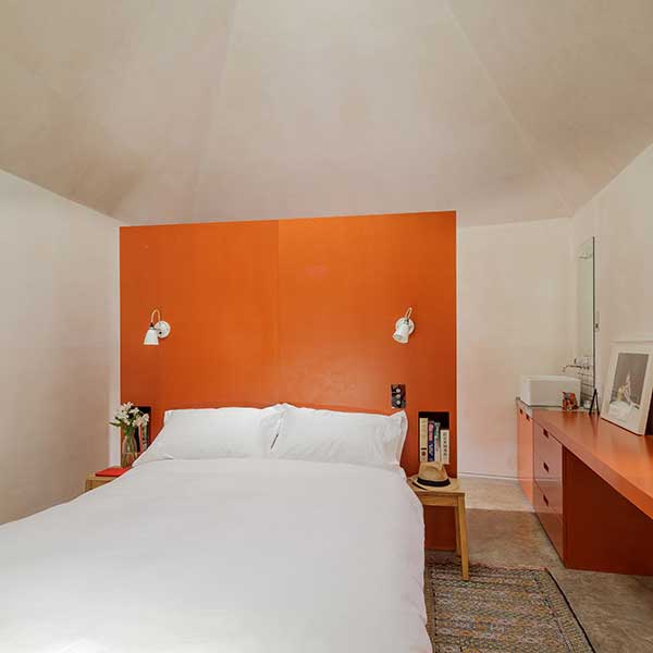 bedroom with orange furniture and white bedding