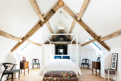 This master suite within the roof space of this barn conversion features vaulted ceilings for dramatic effect