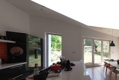 architectural live Courtyard extension features an open-plan kitchen/dinning room under a butterfly roof in Hindhead, Surrey