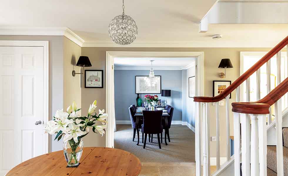 The grand hallway with central staircase and galleried landing opens to various reception rooms on the ground floor
