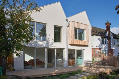 A rendered and cedar clad facade makes up this prefabricated timber frame home