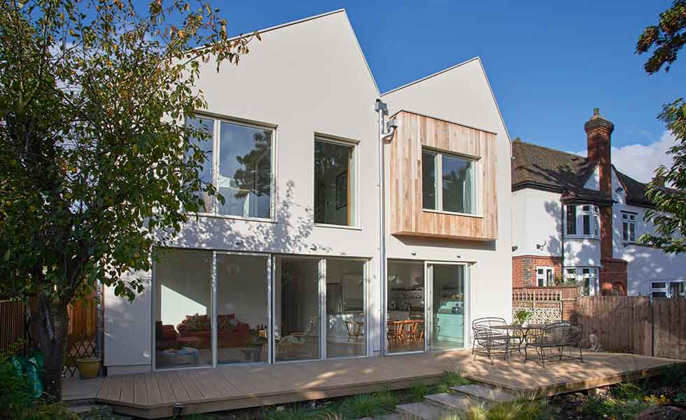 A rendered and cedar clad facade makes up this prefabricated timber frame home