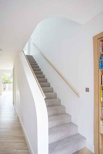 A timber staircase incorporates curves in this prefabricated home