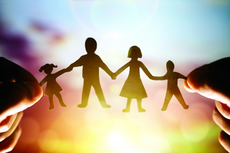 Paper chain family held up to sunset
