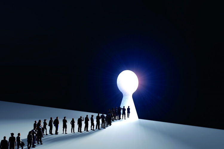 People in front of a bright keyhole opening