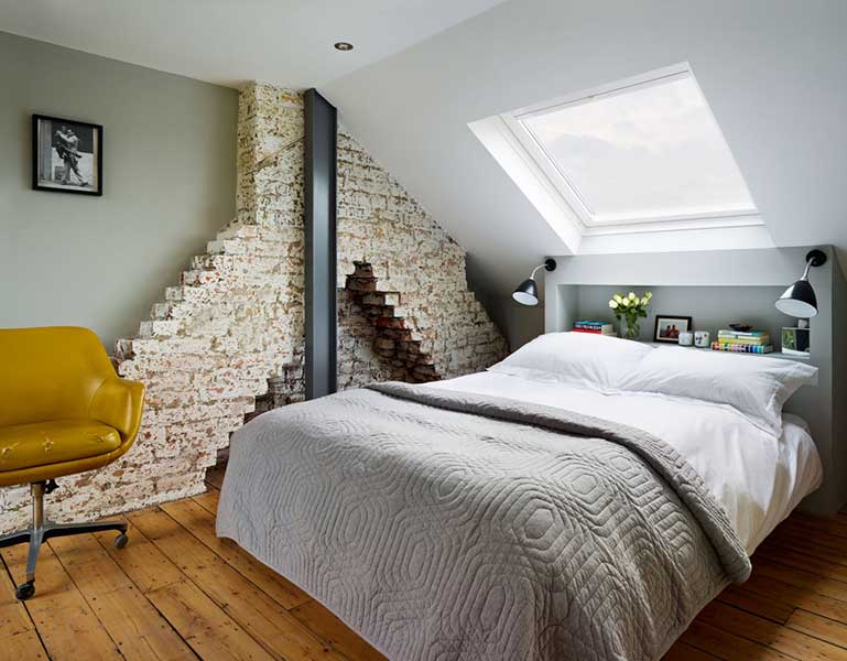 bedroom with an exposed brick wall