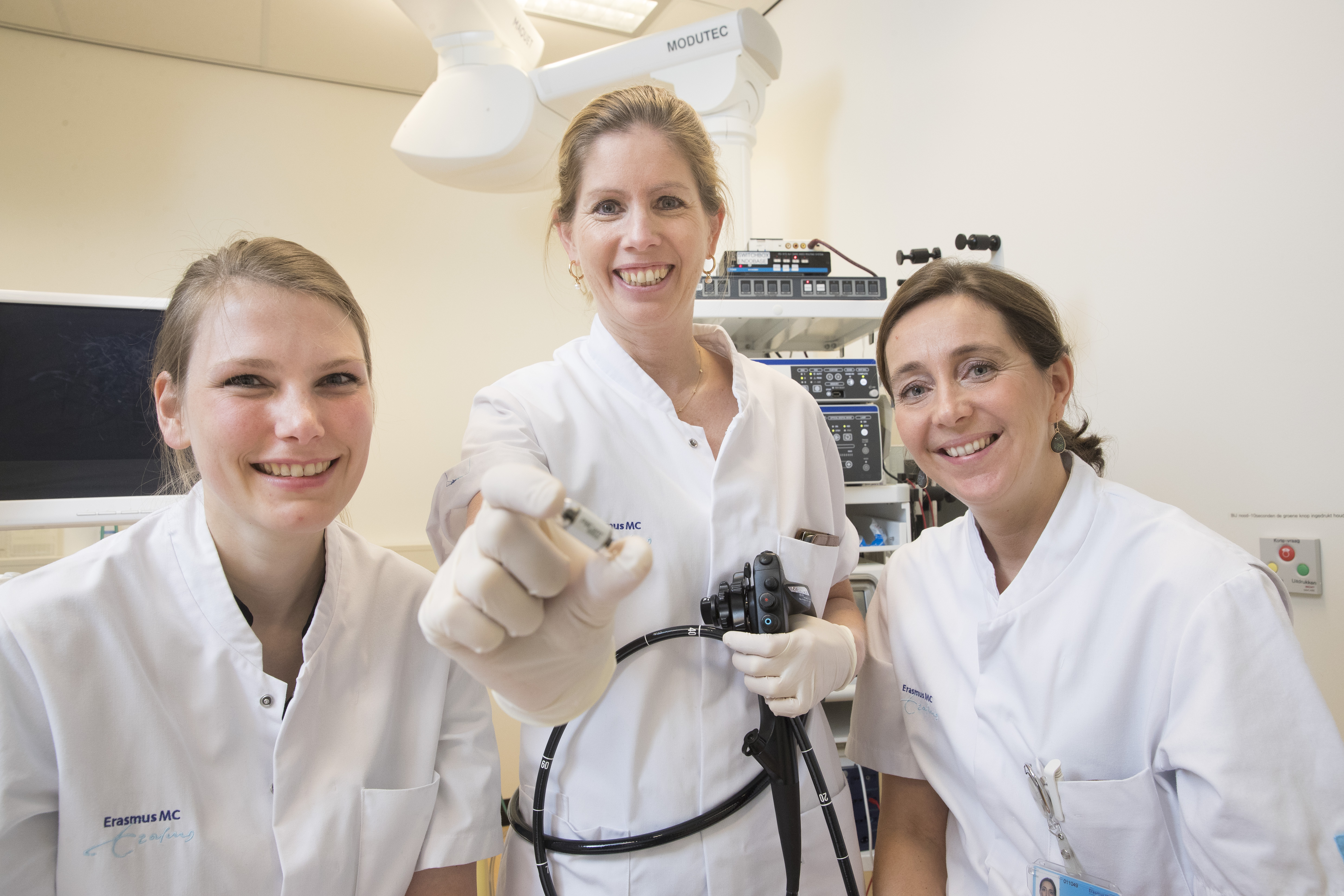 Maag-, Darm- en Leverarts dr. Manon Spaander met de camerapil, geflankeerd door arts-onderzoeker Fanny Vuik (links) en researchverpleegkundige Sophia van Baalen.