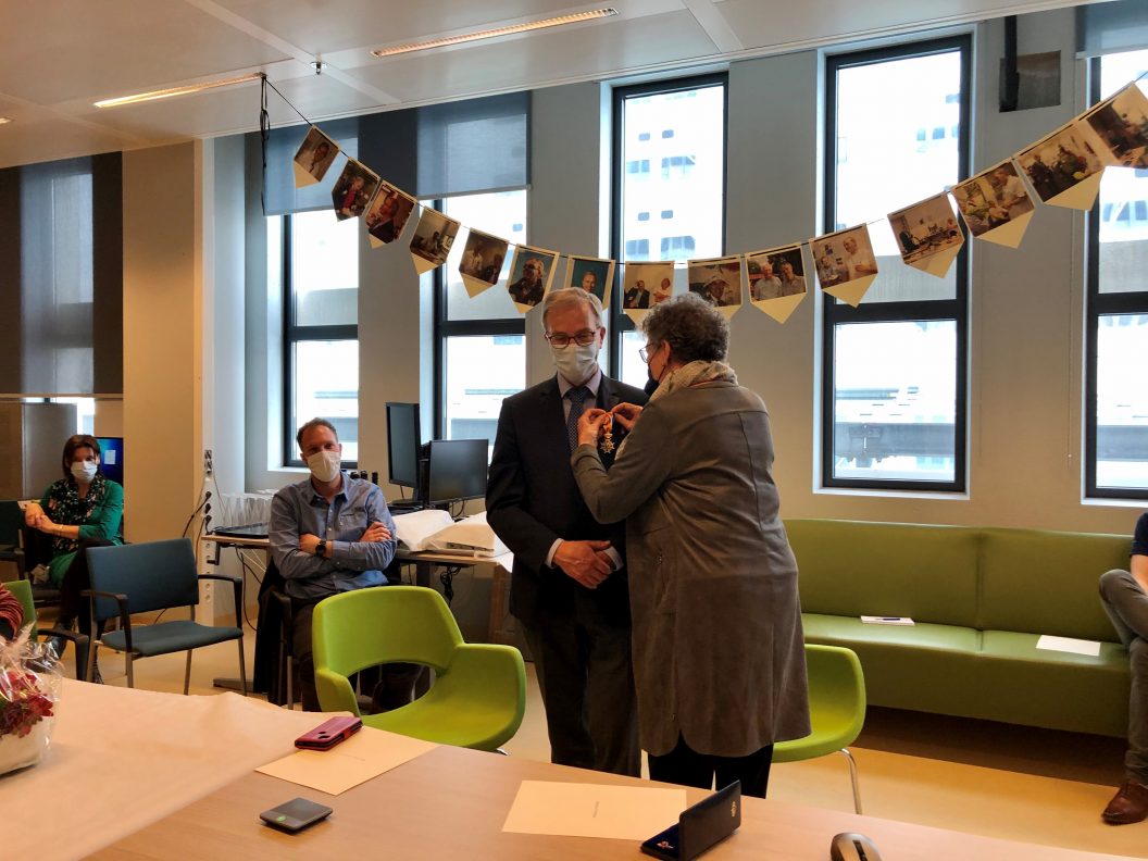 Professor Verhaar krijgt zijn lintje opgespeld door echtgenote Joke