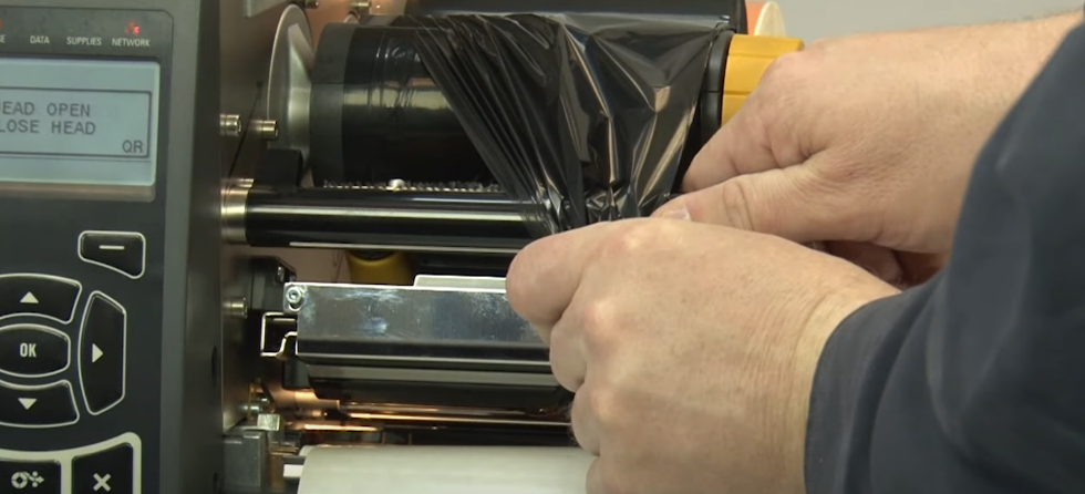 A close-up of a hand holding a black plastic wrap

AI-generated content may be incorrect.