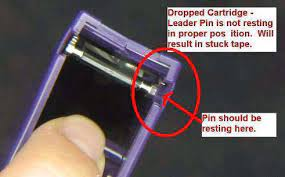 Dropped tape cartridge with the leader pin not resting in its proper position, circled in red to show where it should be seated