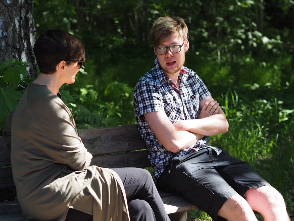 Minna ja Rudi keskustelevat puistonpenkillä istuen