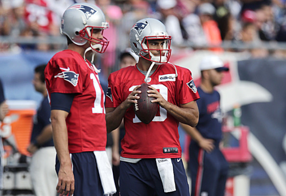 New England Patriots quarterback Jimmy Garoppolo, right, clutches the football as he stands with Tom Brady at an NFL football training camp, Wednesday, Aug. 5, 2015, in Foxborough, Mass. (AP Photo/Charles Krupa)